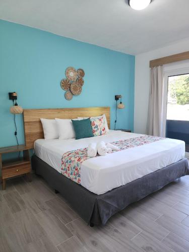 a bedroom with a large bed with blue walls at Alma Del Bosque Hotel in Tortuguero