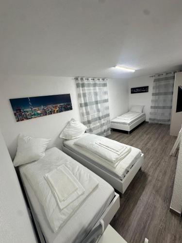 a small room with two beds and a couch at Tolle FeWo direkt am Campus 24-7 Checkin in Germersheim