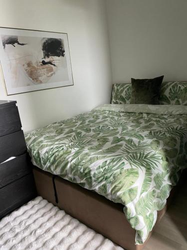 a bedroom with a bed with a green comforter at Cozy Flat with Stunning Views in London