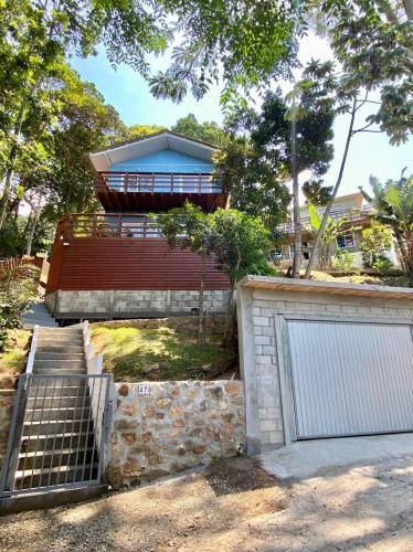 a house with a gate and a garage at Double Deck - Linda vista com Jacuzzi in Palhoça