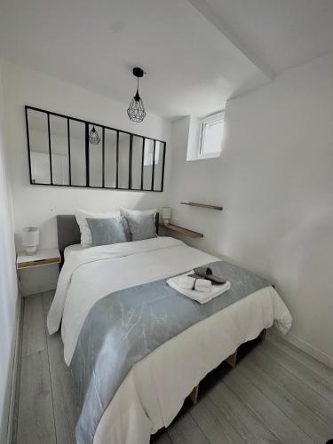 une chambre blanche avec un grand lit dedans dans l'établissement Le Loft de l'Artiste, à Sèvres