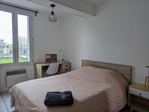 une chambre avec un lit, un bureau et une fenêtre dans l'établissement Appartement T5, au Havre