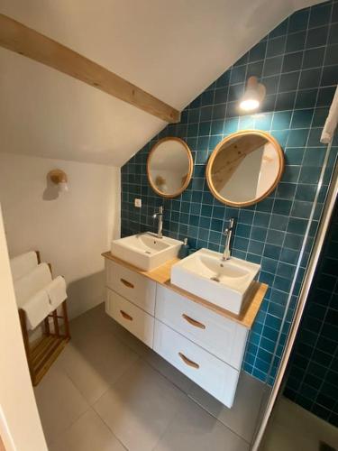 une salle de bain avec deux lavabos et deux miroirs dans l'établissement LA MAISON DES VOSGES Nature & Pool, à Senones