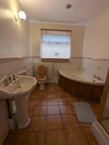 a bathroom with a tub and a toilet and a sink at The Lodge - Built in the 1850s in Clydach