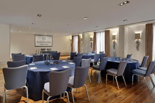 a conference room with blue tables and chairs at Sheraton Heathrow Hotel in Hillingdon