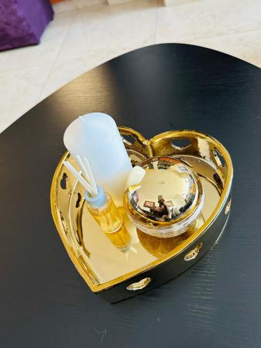 a gold heart shaped container with a candle on a table at Boulevard 208 in Margate