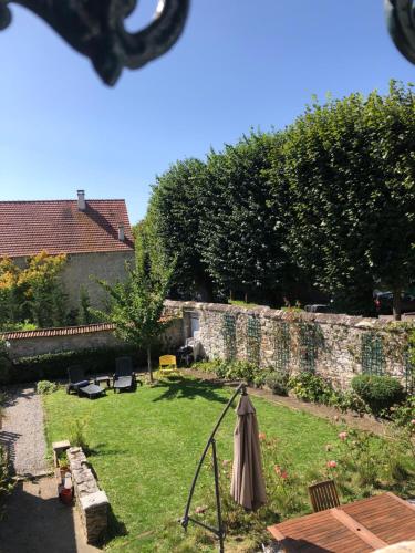 un jardin avec un parasol dans la pelouse dans l'établissement Chez Sophie, à Crépy-en-Valois
