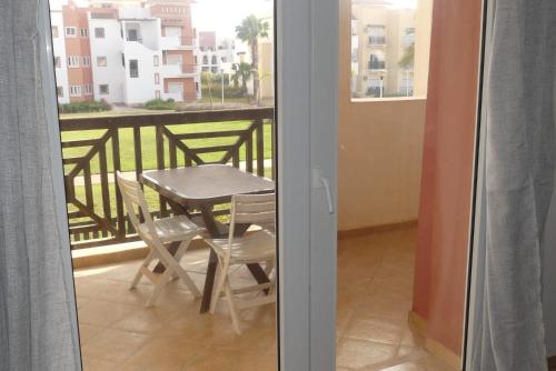 a table and chairs on a balcony with a view at Appartement entier avec parking privé AP4 Saidia in Cherarba