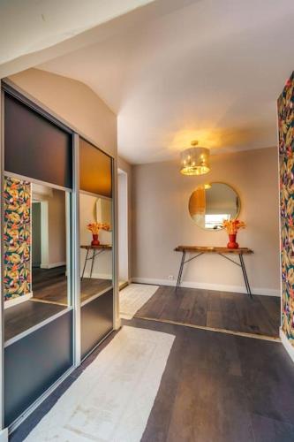 Cette chambre dispose d'un couloir avec un miroir et une table. dans l'établissement Votre cocon à côté des vignes, à Couchey