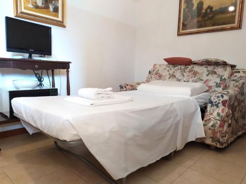 a room with a table and a couch and a tv at Casa Fiorella - Appartamento - Parcheggio gratuito in Beccacivetta
