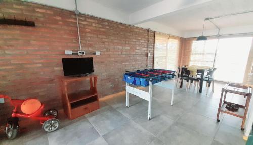 sala de estar con mesa de ping pong y pared de ladrillo en Siu Kiu - Casa de Montaña, en El Parador
