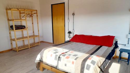 a bedroom with a bed with a red pillow at Siu Kiu - Casa de Montaña in El Parador