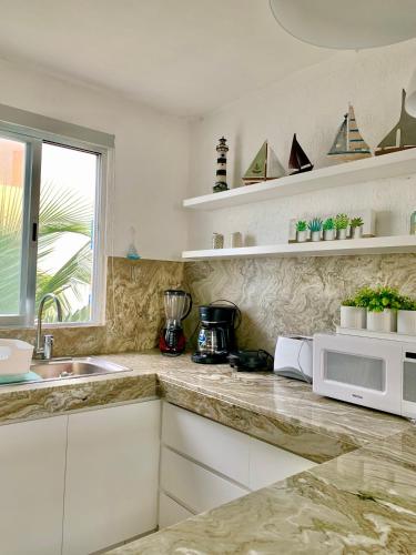 a kitchen with a sink and a microwave at Villa Lulu in Chicxulub