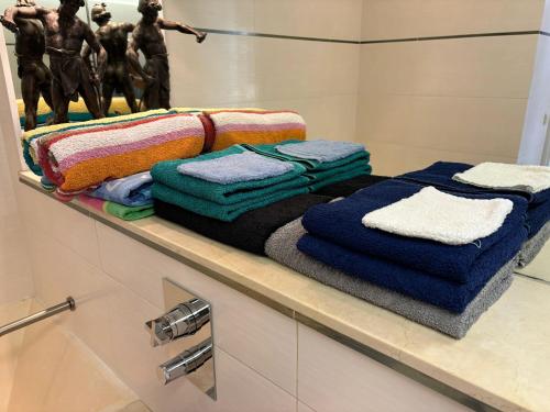 - une étagère avec des serviettes dans la salle de bains dans l'établissement Appartement charmant en bord de mer à Nice 60 m² avec terrasse privée, à Nice