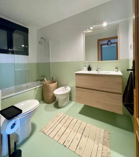 a bathroom with a toilet and a sink and a mirror at THE PLACE - surf & soul in Majanicho
