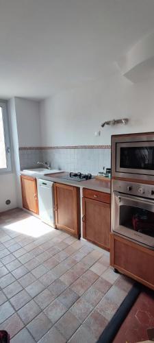 une cuisine avec des armoires en bois et un four à plaques de cuisson dans l'établissement L'Atelier 107, à Marseille