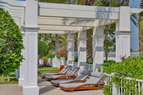 a row of chaise lounge chairs under a pergola at The St. Regis Abu Dhabi in Abu Dhabi