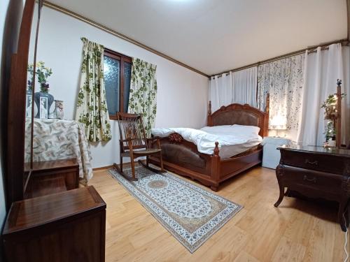 a bedroom with a bed and a chair and a table at Grandmother's Vegetable garden in Anseong