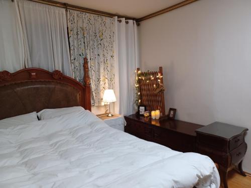 a bedroom with a bed and a desk with a lamp at Grandmother's Vegetable garden in Anseong