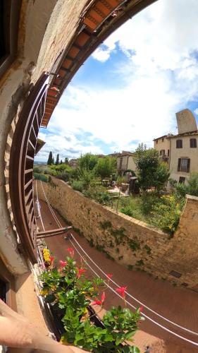 a view of a street from a window with flowers at Casa nel centro storico in San Gimignano