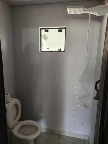 a bathroom with a white toilet and a shower at Casa da lagoa in Barra do Trombudo