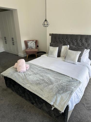 a large bed in a bedroom with a pink pillow on it at Black Horse Apartments in Knaresborough