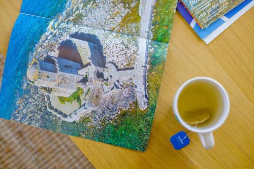 a table with a cup of coffee and a painting at Alethea's Sea View Apartment in Kalamaki