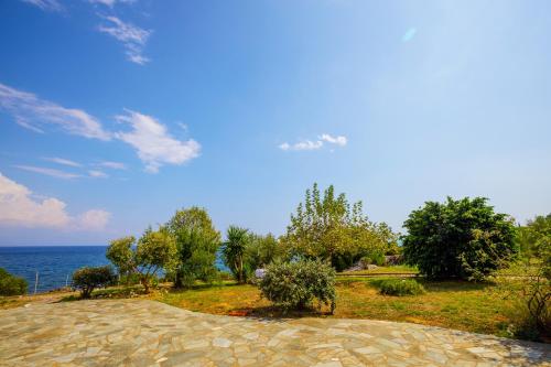 a stone path leading to the ocean on a sunny day at Alethea's Sea View Apartment in Kalamaki