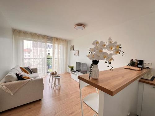 un salon avec une table avec un vase de fleurs dans l'établissement T2 Paris - Stade de France Parking Gratuit, RER, à La Plaine-Saint-Denis