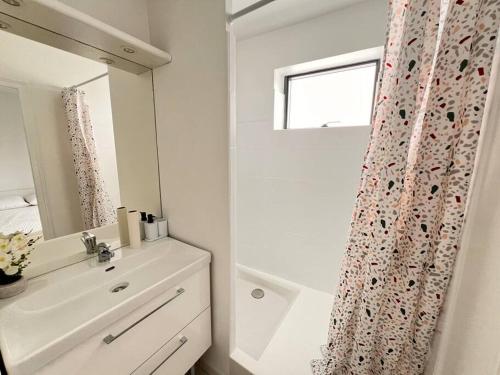 une salle de bain blanche avec un lavabo et un miroir dans l'établissement T2 Paris - Stade de France Parking Gratuit, RER, à La Plaine-Saint-Denis