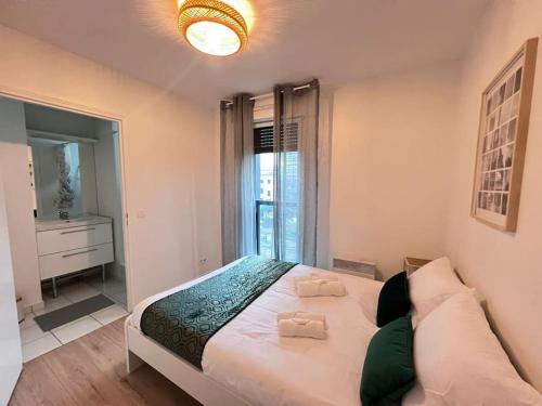 une chambre avec un grand lit avec une grande fenêtre dans l'établissement T2 Paris - Stade de France Parking Gratuit, RER, à La Plaine-Saint-Denis