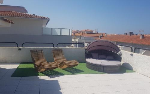 two wooden chairs sitting on top of a roof at Vasco da Gama Apartamento T2 com terraço PRAIA DA BARRA in Gafanha da Nazaré