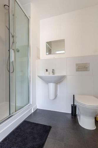 a bathroom with a toilet and a sink and a shower at Stunning Station Apartment with free Parking in Kent