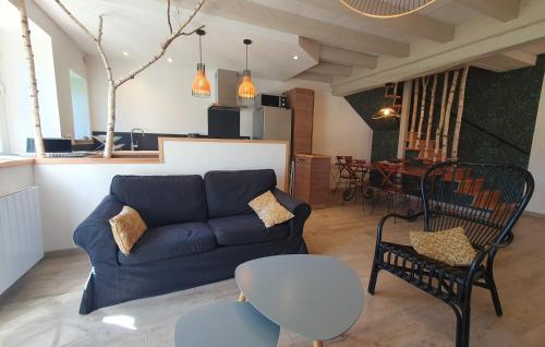 un salon avec un canapé bleu et une table dans l'établissement Au Tilleul, à Crozet