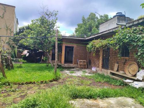 an old brick house with a door in a yard at Casa de la Rosa in Malinalco