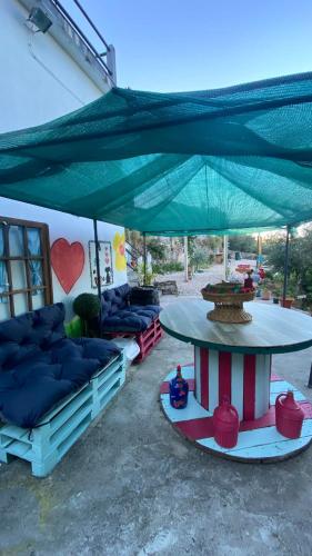 a patio with couches and a table with a large umbrella at Refúgio dos Mauzinhos in Ourondo