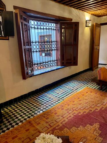 an empty room with a window and a tile floor at Dar Attajalli in Fès