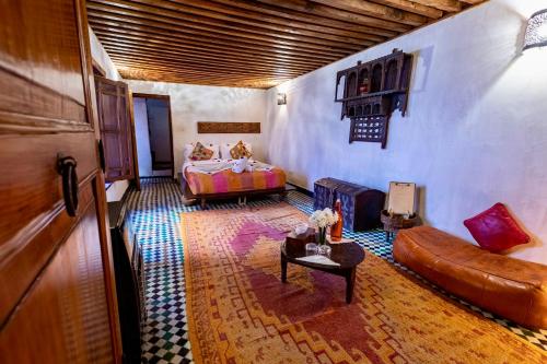 a bedroom with a bed and a couch in a room at Dar Attajalli in Fès