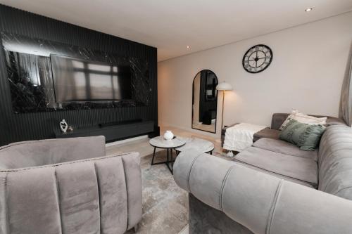 a living room with a couch and a clock on the wall at The paramount in Johannesburg