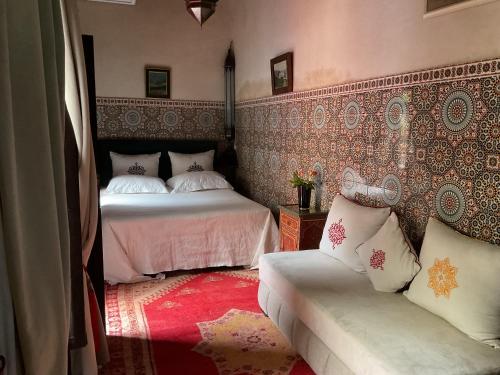 a bedroom with two beds and a couch at Riad Syba in Marrakech