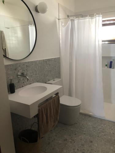 a bathroom with a sink and a toilet and a mirror at Casa da Bisa in Sagres