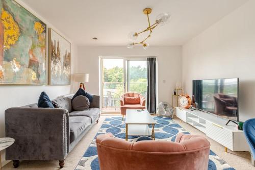 a living room with a couch and chairs and a tv at Stylish Station Apartment in Rochester with Free Parking in Wainscot