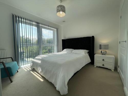 a white bedroom with a large bed and a window at Stylish Station Apartment in Rochester with Free Parking in Wainscot