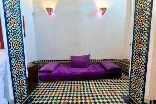 a bedroom with a purple bed in a room at Dar Attajalli in Fès