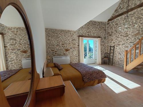 a bedroom with two beds and a mirror at La Source Du Bonheur Chambres et Table d'Hôtes in Rieupeyroux