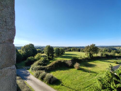 a road through a field with trees on the side at La Source Du Bonheur Chambres et Table d'Hôtes in Rieupeyroux