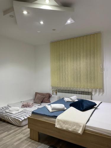 a bedroom with two twin beds and a window at Centar Holiday Smederevo in Smederevo