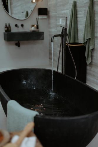 a black sink with a faucet in a bathroom at Te Whaanga Retreat & Spa in Raglan