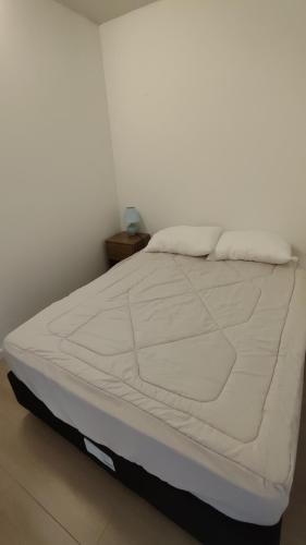 ein großes weißes Bett in einem Zimmer mit einer weißen Wand in der Unterkunft Casa de playa océan park in Sauce de Portezuelo