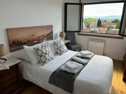 a bedroom with a white bed with a large window at El Rincón de Muxiña in Monforte de Lemos